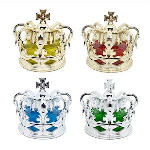 Könnte beinhalten: Vier dekorative kronenförmige Objekte. Zwei sind goldfarben und zwei silberfarben. Jede Krone hat ein Kreuz oben und ein farbiges juwelenartiges Zentrum: gelb, rot, blau und grün. Die Kronen haben ein rautenförmiges Muster am Sockel.