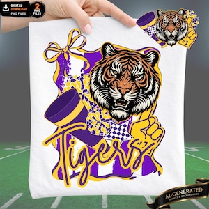 Könnte beinhalten: Ein weißes T-Shirt mit einer Grafik, die einen Tigerkopf, ein violettes Megafon, gelbe Pompons und einen gelben Schaumstofffinger mit der Nummer 1 zeigt. Das Wort Tigers ist in gelber Schreibschrift unter dem Tigerkopf abgebildet.