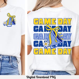 Puede incluir: Camiseta blanca con diseño azul y amarillo. La parte delantera presenta un megáfono con un lazo y una margarita. La parte trasera de la camiseta tiene las palabras "GAME DAY" en amarillo y azul, con un gráfico de megáfono.