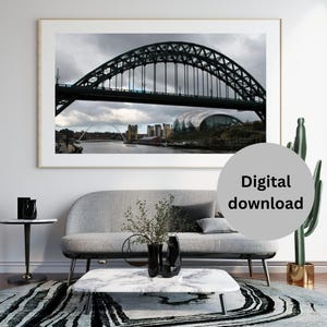 Puede incluir: Fotografía enmarcada de un puente de arco verde oscuro sobre un río bajo un cielo nublado. La imagen incluye el texto "Descarga digital" en un círculo gris.