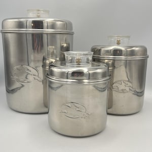 Puede incluir: Juego de cuatro botes de acero inoxidable con tapas de plástico transparente. Cada bote tiene un diseño en relieve de una liebre corriendo. Los botes son de diferentes tamaños, adecuados para el almacenamiento en la cocina.