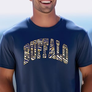 May include: Navy blue crew neck t-shirt with the word "BUFFALO" in a gold and white zebra print design across the chest. The shirt is short-sleeved and made of a lightweight material.