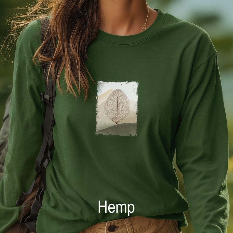 May include: Dark green long-sleeve shirt with a rectangular graphic of a leaf and mountain scene. The word "Hemp" is printed at the bottom of the shirt in white. The shirt is made of a soft, comfortable material.