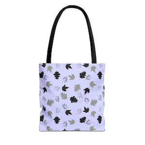 May include: A tote bag with a light purple background and a repeating pattern of black, gray, and olive green leaves and berries. The bag has black handles.