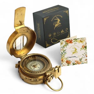 May include: A vintage brass compass with a hinged lid, open to reveal the compass face. A black box with gold lettering and a floral card that reads "Gift of Love... Especially for U" are also in the image. The box says "Houston Souvenir".