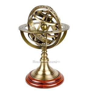 May include: A vintage brass armillary sphere with zodiac symbols and degree markings. The sphere is mounted on a wooden base and is a decorative item. The sphere is a detailed replica of an astronomical instrument.