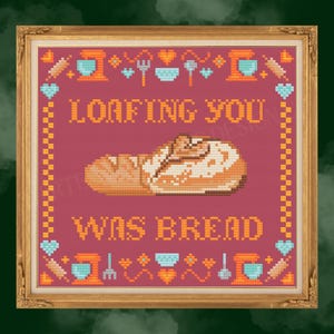 Puede incluir: Obra de arte de punto de cruz en un marco dorado. La obra presenta el texto "LOAFING YOU WAS BREAD" encima y debajo de una imagen pixelada de una hogaza de pan. Iconos temáticos de panadería y un borde de corazones y puntadas rodean el texto.