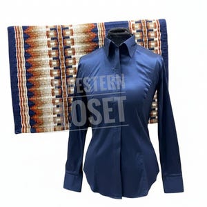 Op de afbeelding: Een marineblauw shirt met lange mouwen en een kraag. Achter het shirt ligt een zadeldek met een geometrisch patroon in bruin-, beige- en blauwtinten. De tekst "WESTERN OSET" is op het shirt gedrukt.
