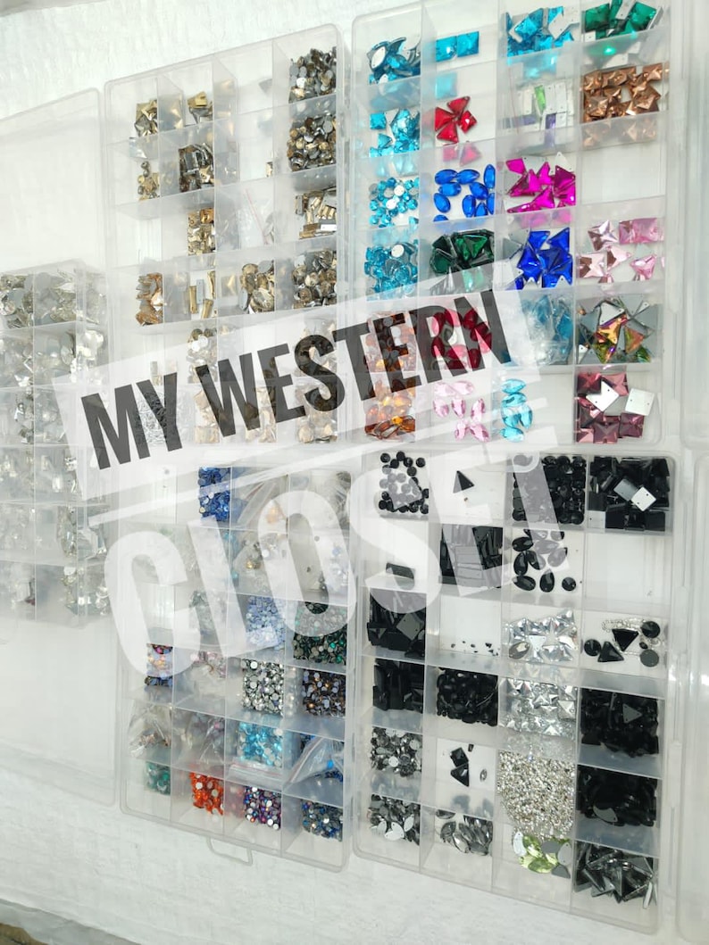 May include: Clear plastic organizer filled with various colorful rhinestones and gems. The compartments hold different shapes and sizes of crystals in shades of silver, gold, blue, pink, and black. Text on the image reads "MY WESTERN CLOS".