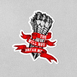 May include: A sticker with a black and white illustration of a clenched fist in armour, with a red banner that reads "YOU WILL NOT BREAK ME". The design has a bold, graphic style.