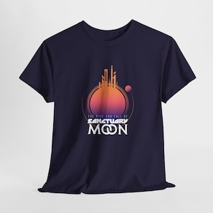 May include: Navy blue t-shirt featuring a graphic design with a cityscape silhouette inside a circle, with a gradient of orange and pink. The text reads "THE RISE AND FALL OF SANCTUARY MOON".