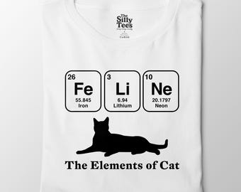 May include: White t-shirt featuring a black cat silhouette and the phrase "The Elements of Cat." Above the cat are the periodic table symbols Fe, Li, and Ne, representing Iron, Lithium, and Neon.