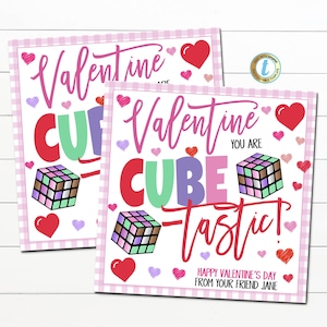 May include: Two Valentine's Day cards with a pink gingham border. The cards feature the words "Valentine" and "Cube-tastic" in various colors, along with Rubik's Cubes and hearts. The bottom of the card reads "Happy Valentine's Day from your friend Jane."