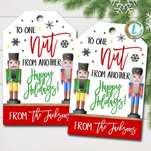 May include: Two printable gift tags featuring a nutcracker design. The tags are white with red, green, and blue accents. The text on the tags reads "To one nut from another Happy Holidays!" and "From: The Jacksons".
