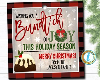 May include: A red and black buffalo plaid gift tag with a white woodgrain background. The tag features a red and white illustration of a Christmas pudding and the text "Wishing you a Bundt'ch of Joy this holiday season Merry Christmas! From the Jackson Family".