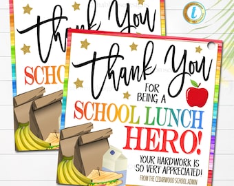 May include: Two colorful thank you tags with a rainbow border and gold stars. The text reads "Thank You for being a School Lunch Hero! Your hard work is so very appreciated! From the Cedarwood School Admin". The tags feature a cartoon image of lunch bags, bananas, and a sandwich.