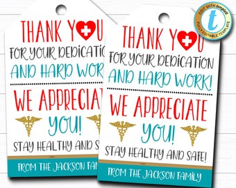 May include: Two white gift tags with a red heart and a red medical cross. The tags say "Thank You for your dedication and hard work! We appreciate you!" and "Stay healthy and safe! From the Jackson family".