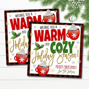 May include: Two printable gift tags with a red and black buffalo check background. The tags feature a red mug with whipped cream and a snowflake. The text on the tags reads "Wishing you a warm and cosy holiday season! Merry Christmas! Love, the Jacksons".