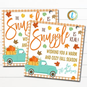May include: A printable gift tag featuring a blue pickup truck with a load of pumpkins and autumn leaves. The text reads "The Snuggle is Real! Wishing you a warm and cosy autumn season. Love, The Jacksons".