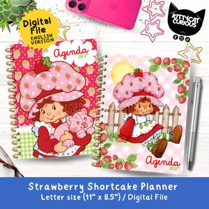Puede incluir: Dos agendas 2027 de espiral con ilustraciones de Strawberry Shortcake. La portada izquierda tiene un patrón de fresas rojas, mientras que la derecha muestra un personaje junto a una valla sobre un fondo de cuadros rosa. Ambas miden 27,9 por 21,6 cm.