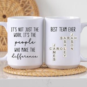 K&ouml;nnte beinhalten: Zwei wei&szlig;e Keramikbecher mit schwarzem Text. Auf einem Becher steht "IT'S NOT JUST THE WORK, IT'S THE people WHO MAKE THE difference." Der andere Becher sagt "BEST TEAM EVER" mit Namen.