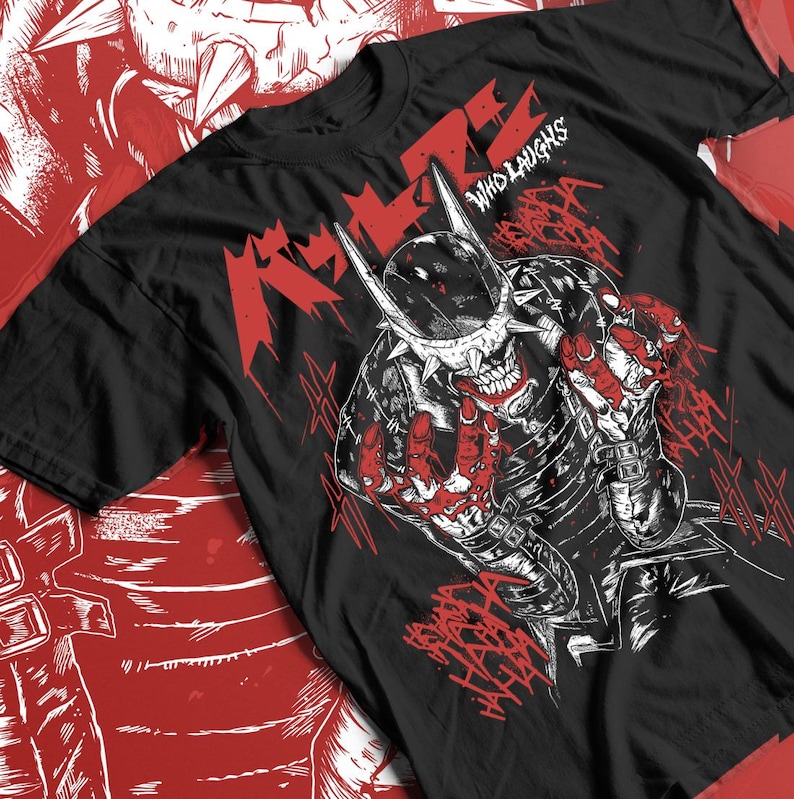 May include: Black t-shirt with a red and white graphic design. The design features a skull-like character with sharp teeth and a spiked helmet. The text "WHO LAUGHS" is above the character, and the word "LAUGHS" is in a stylized font.