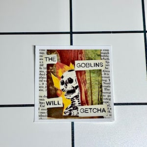 May include: A square sticker with a collage design. The design features a skull with a flame, the words "THE GOBLINS WILL GETCHA" and a background of text and colors.