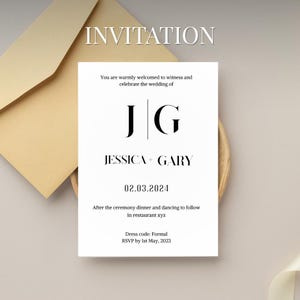 May include: A white wedding invitation with black text, featuring the initials "JG" and the names "Jessica + Gary." The date "02.03.2024" is displayed. The invitation is placed on a wooden plate, with a beige envelope in the background.