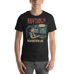 May include: Dark gray t-shirt with a graphic design featuring a distressed illustration. The design includes the text "EDITOR'S CUT (OFF)" and a scene of a person at a computer with the text "WHERE'S MY ALT TAKE?" and "ONE WRONG EXPORT... AND YOU'RE DEAD TO THE TEAM."