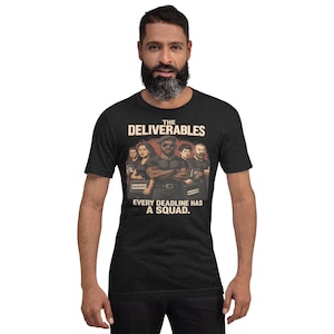May include: Dark grey t-shirt with a graphic of a team of people and the text "THE DELIVERABLES" above and "EVERY DEADLINE HAS A SQUAD" below. The shirt is worn by a person.