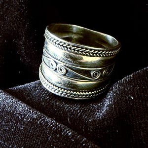 Bali-style sterling band ring with rope borders and a central oxidized scrollwork pattern. Size 10.5