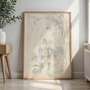May include: Abstract landscape art print in a light wood frame. The artwork features a soft, muted color palette with shades of white, blue, and green. The image depicts a blurred outdoor scene with trees and a path, creating a serene atmosphere.