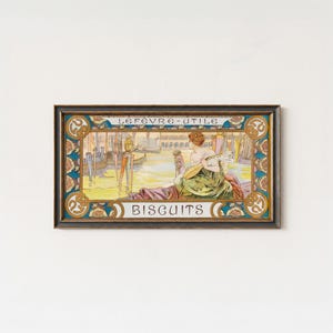 May include: A rectangular framed print featuring a vintage advertisement for Lefevre-Utile Biscuits. The illustration depicts a person playing a lute by a canal with gondolas, rendered in soft pastel tones of yellow, blue, and green with ornate borders.
