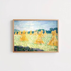 May include: A framed impressionist painting depicting a field of golden wheat stacks under a light blue sky. The artwork features textured brushstrokes in shades of yellow, green, and blue, with the signature Claude Monet visible in the bottom right corner.
