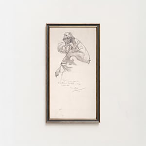 May include: A framed charcoal drawing on off-white paper featuring a figure in a head covering, rendered with expressive lines. The artwork includes handwritten text and a signature at the bottom, enclosed in a dark, thin rectangular frame.