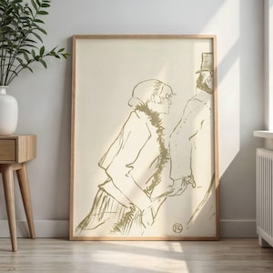 May include: A framed art print featuring a gold-toned line drawing of two figures in profile. The woman wears a coat with a fur collar, and the man wears a top hat. The artwork is set against a cream-colored background, with a wooden frame.