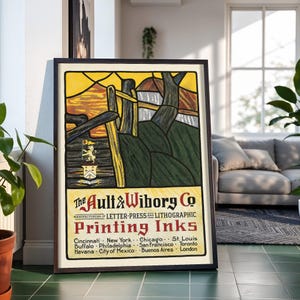May include: A framed vintage advertisement poster for The Ault & Wiborg Co. featuring a stylized landscape with a yellow sky, dark green hills, and a heraldic crest. The text reads: The Ault & Wiborg Co. Manufacturers of Letter-Press and Lithographic Printing Inks.