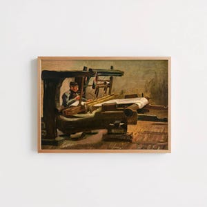 May include: A framed oil painting depicting a person operating a large wooden loom. The scene features dark brown and muted earth tones, showing the individual seated at the machinery with white fabric being woven. The frame is a light wood color.