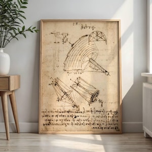 Può includere: Una stampa incorniciata che presenta un disegno tecnico color seppia di componenti meccanici con note scritte a mano. L'illustrazione mostra diagrammi geometrici, tra cui una grande struttura circolare e parti cilindriche, accompagnati da un denso testo in corsivo.