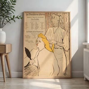 Puede incluir: Póster vintage enmarcado con texto en francés que muestra a una mujer con cabello amarillo siendo peinada por otra persona. El póster incluye "Le Théâtre Libre" y "Le Poète et le Financier". La obra está enmarcada en madera.
