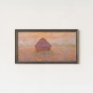 May include: A rectangular framed painting depicting a haystack in a field during sunset. The artwork features soft brushstrokes in shades of pink, orange, and purple, capturing a hazy atmosphere. The painting is enclosed in a dark, textured frame.