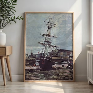 May include: A framed print of a vintage painting depicting a tall ship docked in a harbor. The artwork features a muted color palette with a focus on the ship's masts and rigging against a cloudy sky. The frame is made of light-colored wood.