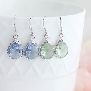 Puede incluir: Cuatro pares de pendientes en forma de l&aacute;grima con ganchos plateados. Los pendientes presentan piedras facetadas de color azul claro y verde.