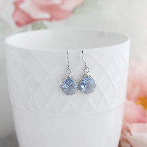Puede incluir: Un par de pendientes de plata con cristales de color azul claro en forma de l&aacute;grima.