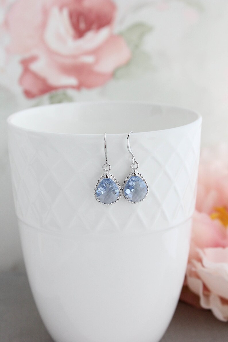Puede incluir: Un par de pendientes de plata con cristales de color azul claro en forma de l&aacute;grima.