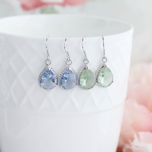 Puede incluir: Tres pares de pendientes colgantes en forma de l&aacute;grima con ganchos plateados. Los pendientes presentan piedras de cristal facetadas en azul claro y verde claro.