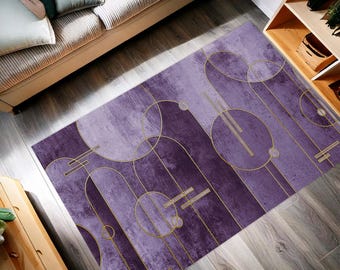 May include: A rectangular purple area rug with an abstract design. The rug features a watercolor-like background with gold geometric shapes, including circles and lines. The rug is placed on a wooden floor.