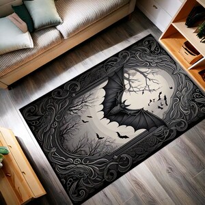 Puede incluir: Una alfombra rectangular con un diseño gótico que presenta un gran murciélago con las alas extendidas, árboles silueteados y una luna llena. La alfombra tiene una combinación de colores negro y gris con detalles de borde ornamentados, creando un tema de Halloween espeluznante.