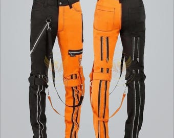 Op de afbeelding: Tweekleurige broek met een opvallend ontwerp. De ene kant is zwart, de andere is feloranje. Elke broekspijp heeft meerdere ritsen en bandjes. De broek heeft een unieke, edgy stijl, geschikt voor alternatieve mode. Afmetingen in cm.