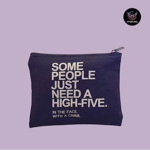 May include: A navy blue zippered pouch with the text "SOME PEOPLE JUST NEED A HIGH-FIVE. IN THE FACE, WITH A CHAIR." in white. The pouch has a black zipper and a small logo in the upper right corner.